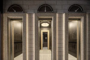 Granite columns with elevator doors in an interior setting.