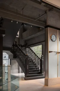 Industrial-style concrete staircase with metal railings and exposed beams in a modern interior space.
