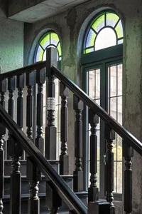 Industrial-style staircase with wooden balusters and glass-paneled windows.