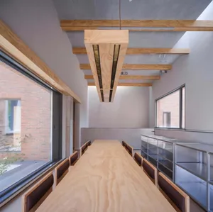 A minimalist office space featuring wood, glass, and concrete materials.