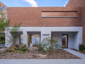 Modern building exterior with brick facade and rock garden