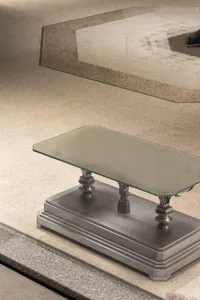 A modern metal side table with a glass top