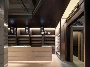 Modern retail shop with concrete exterior and illuminated signage.