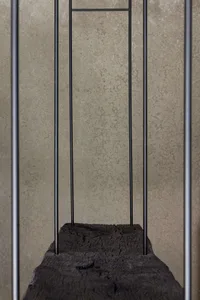 a minimalist clothing rack made of charred wood and steel