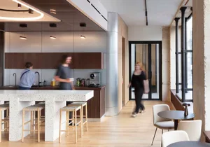 A modern commercial interior with a concrete bar, industrial-style lighting, and minimalist furniture.