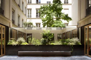 A modern indoor space featuring a rooftop garden with lush green plants.