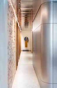 A modern interior corridor made of aluminum with a minimalist design and white speckled flooring.
