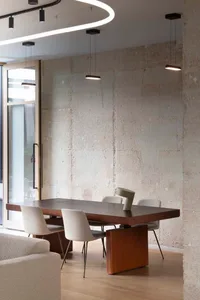 A modern office setting featuring a wooden table with minimalist chairs.