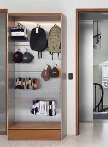 A modern retail display featuring metal shelving and stone finishes with a variety of products such as backpacks, socks, and 