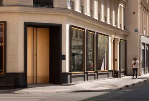 A modern retail storefront featuring large glass windows and a wooden door.