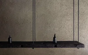 A minimalist, modern shelf with wooden elements against a textured wall.