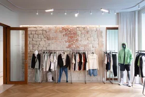 Clothing store with brick walls, wooden floors, and hanging racks