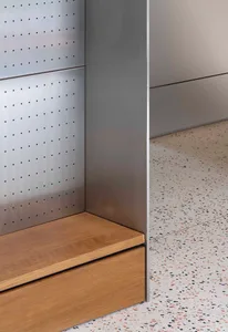 An industrial interior featuring metal walls, wooden accents, and terrazzo flooring.