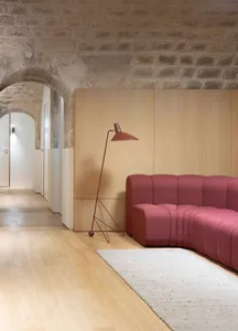 Contemporary living room featuring wooden flooring and a pink fabric sofa with a red floor lamp.