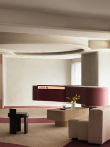 A modern lobby featuring concrete material with a circular ceiling light fixture and white walls.