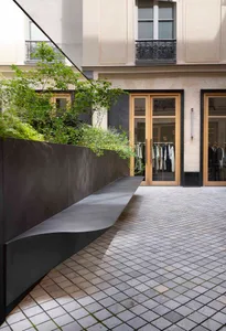 現代街景建築，搭配混凝土步道與綠意植栽。