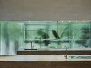 Modern kitchen featuring a marble countertop and a glass dividing wall.
