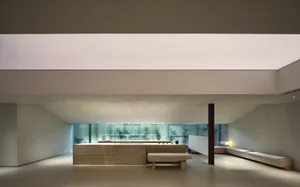 A modern residential space featuring a minimalist design with concrete walls and floors.