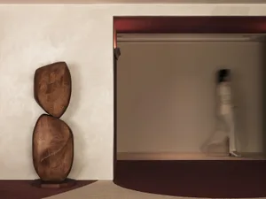 Modern interior design featuring a wooden abstract sculpture with smooth, rounded shapes.