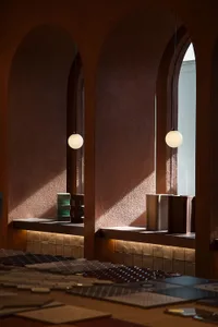 A cozy cafe interior featuring warm lighting, cement-tile surfaces, and modern fixtures.