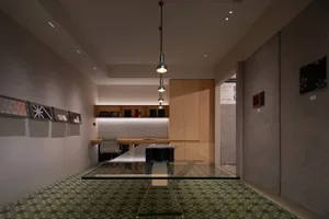 A minimalist office space featuring a glass table and modern design elements.