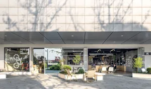 A minimalist retail storefront with concrete and glass materials.