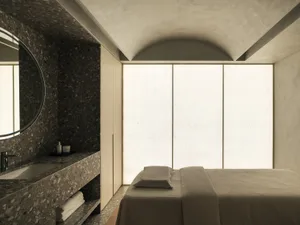 A modern bedroom with terrazzo flooring and a minimalist design.