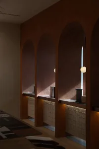 A modern commercial space with concrete accents, featuring a series of arches and a light fixture.