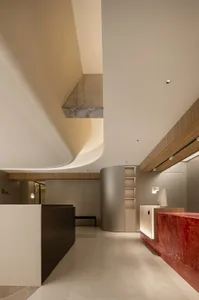 A minimalist modern lobby featuring concrete, wood, and marble materials.