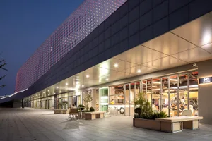Modern retail storefront with metal cladding and illuminated signage.
