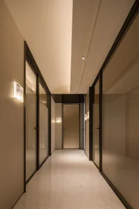 A modern corridor with glass doors and marble flooring.