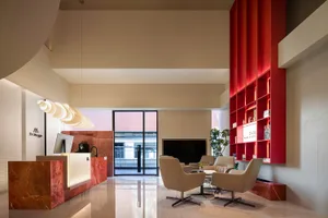 A modern lobby with glass walls, black marble countertops, and porcelain tiled floors.