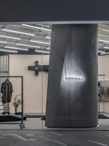 Modern retail storefront with a concrete pillar and metal accents.