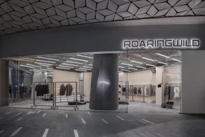 A modern storefront with glass walls and a concrete pillar.
