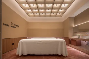 現代水療室內有混凝土牆面，以及覆蓋著質感白色毯子的白色沙發。