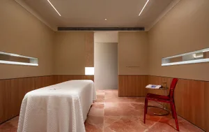 Modern spa room with a white bed on a marble floor