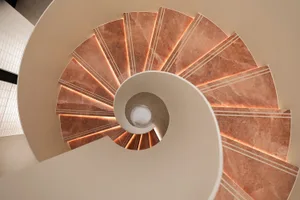 Spiral staircase made of marble with a circular design.
