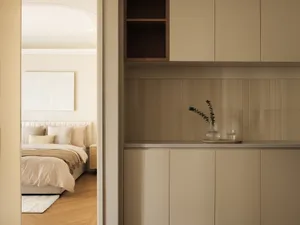A minimalist bedroom with cork cabinetry and a bed.