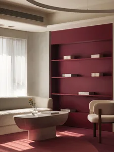 A minimalist living room with a red shelving unit and white furniture, featuring a table, a chair, and a window with sheer cu