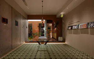 A modern lobby with a contemporary concrete design, featuring minimalist furniture and a green plant.