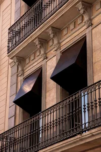 A stone and metal exterior building facade with decorative railings.