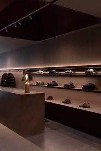 An industrial retail interior showcasing metallic finishes, leather accessories, and wooden furniture.