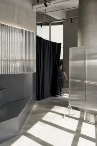 Grey metal structure with black curtains and light fixture