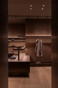 A minimalist clothing and shoe retail store featuring wooden materials and sleek, modern design.