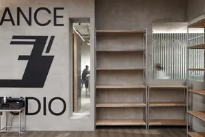 Minimalist office setting with metal and wood shelving and concrete walls