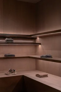 Modern clothing shop with wooden shelves displaying folded garments.