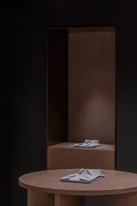 A sleek, modern interior design featuring a wooden display with folded shirts.