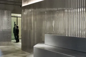 A modern office reception area featuring metallic walls and minimalist design elements.