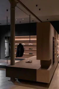 A modern retail storefront with minimalist design, featuring wood and concrete elements.