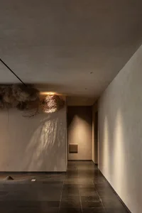 Fabric lighting fixture in a corridor with concrete walls and floor tiles.